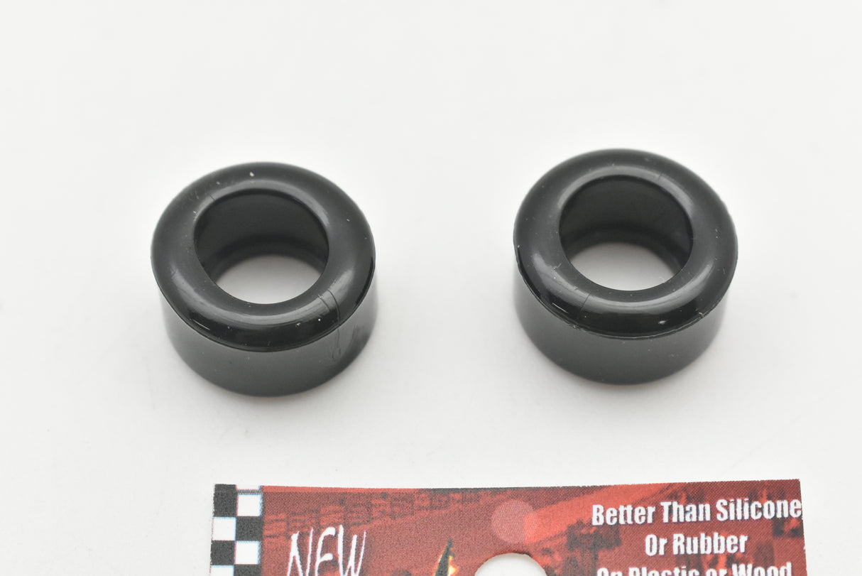 Two black, circular model car wheels on a white background for 1:32 Carrera Ferrari 512