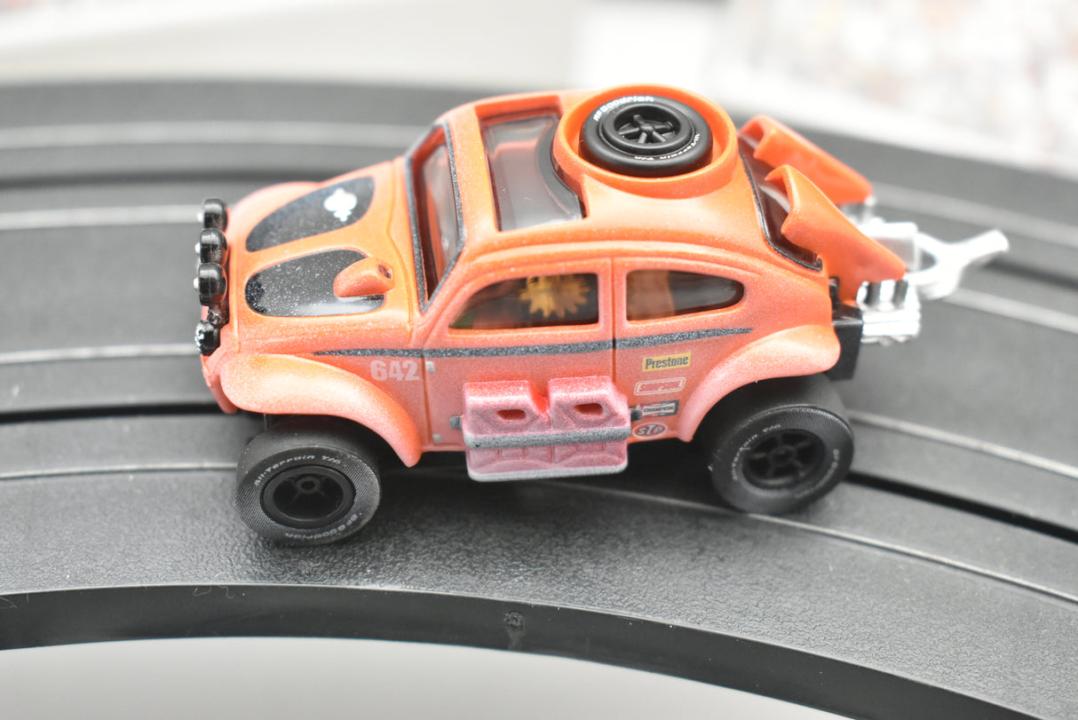 Orange VW Beetle toy car with dirt effect on a track for Auto World SC011