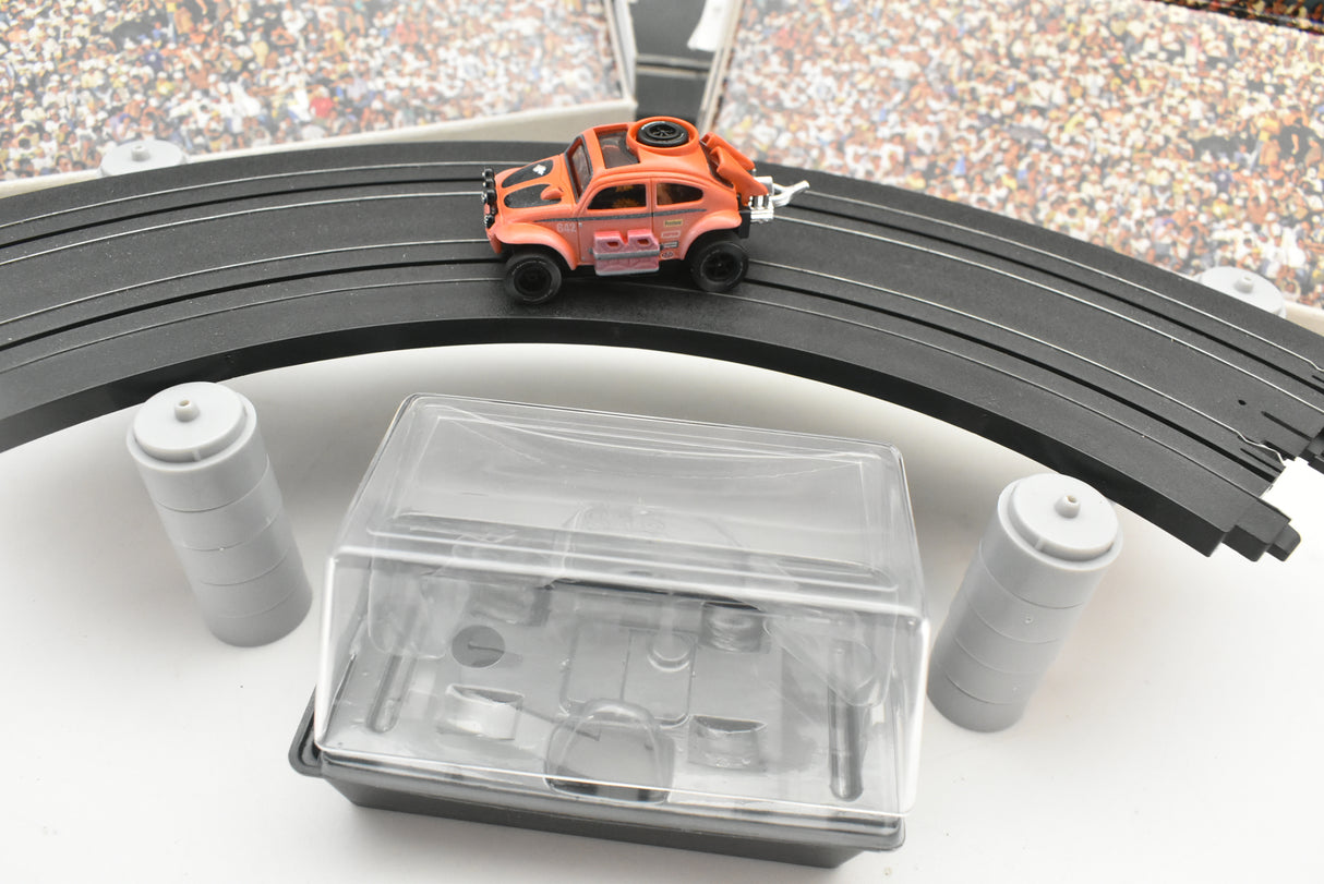 Orange VW Beetle car on black track with accessory pieces for Auto World SC011