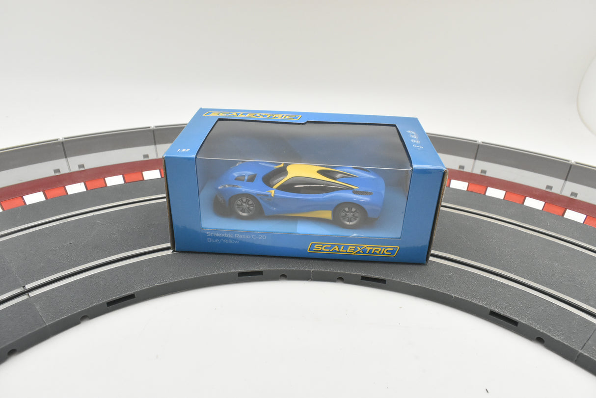 Blue and yellow race car in its box, displayed on a track section for Scalextric C4141T