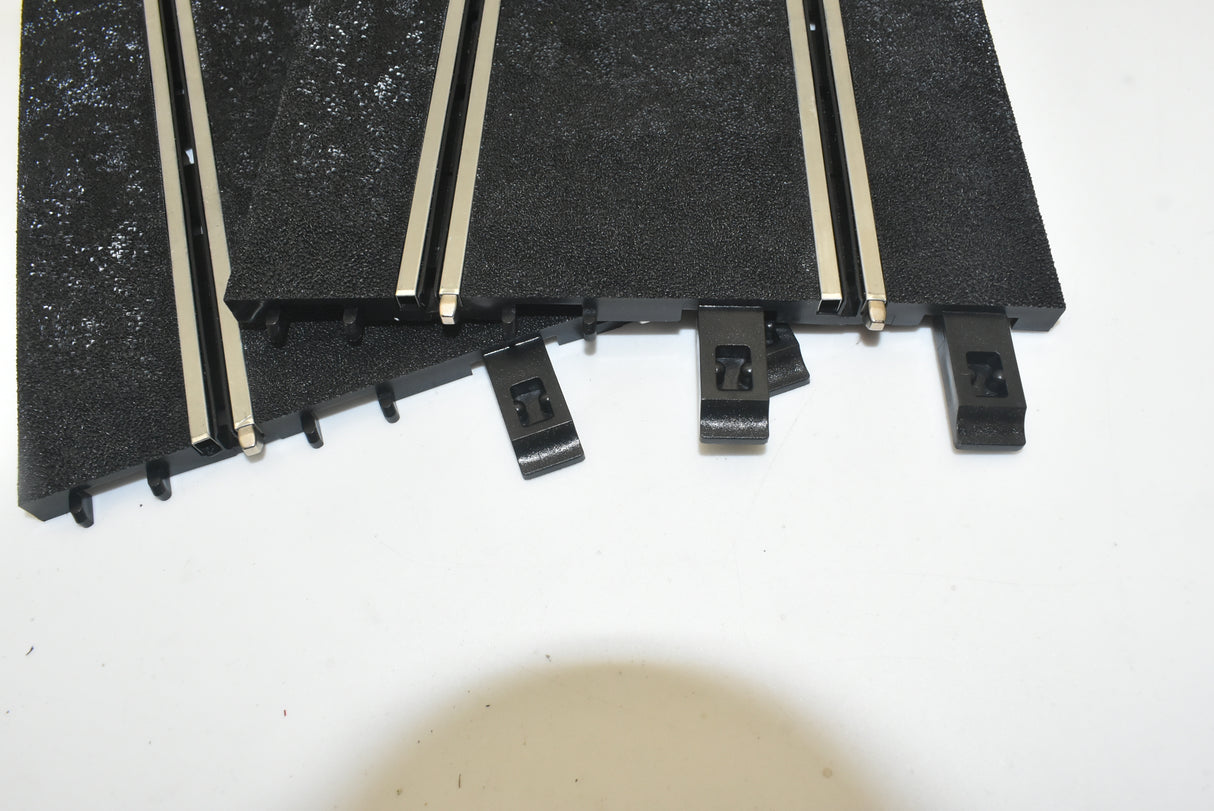 Black straight track sections for display, showing mounting brackets for Ninco 10103