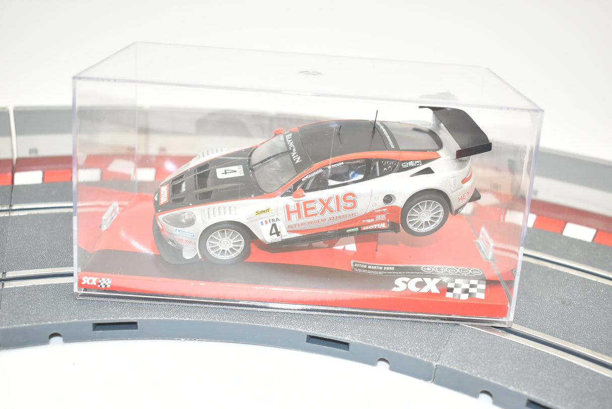 Slot car of a white Aston Martin DBR9 race car on a track for SCX A10141X3U0