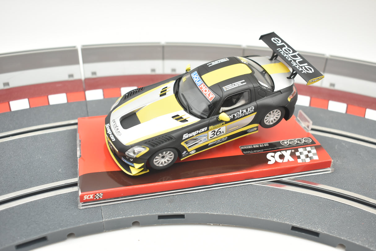 Yellow and black Mercedes SLS GT3 race car on a track base for SCX A10154X3U0