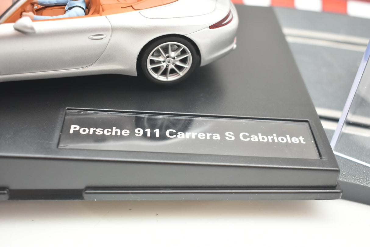 Slot car of a Porsche 911 Carrera S Cabriolet on its display base for 27535