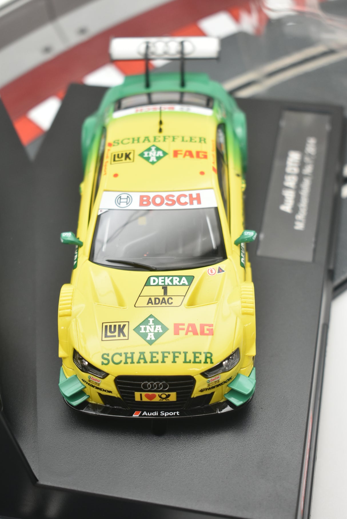 Yellow race car model, front view, featuring sponsor decals for Carrera 274730