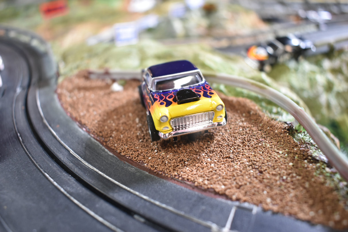 Yellow and blue 1955 Chevy Bel Air slot car on a slot car track for Slot Car 1:64 CP7726