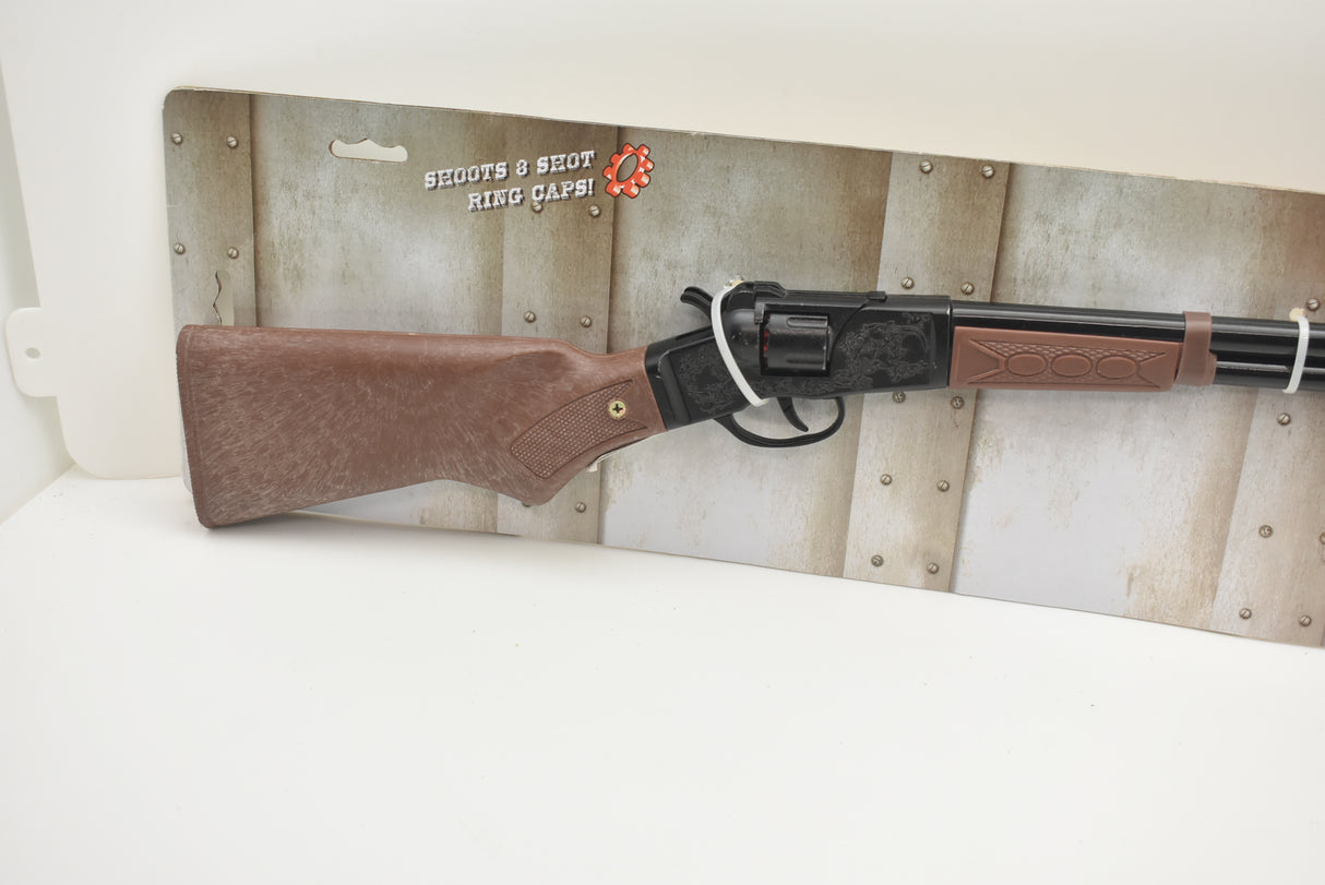 Toy rifle with brown stock, displayed on a wooden backdrop for Parris Toys 4722