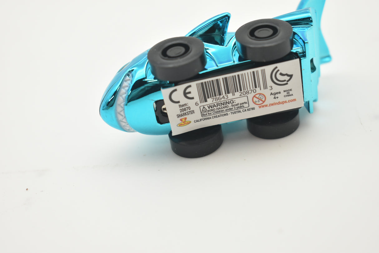 Blue toy vehicle with black wheels and warning labels visible for California Creations 20553