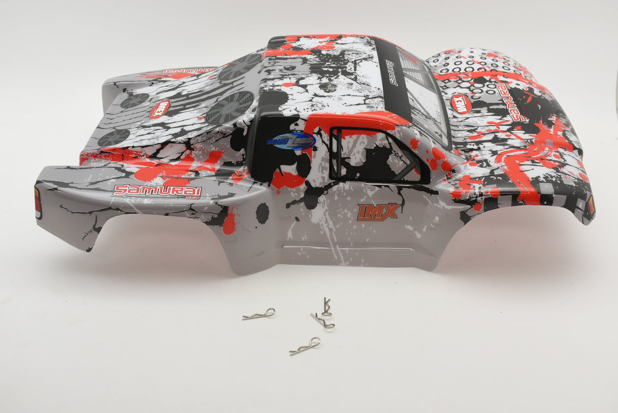 Red and black printed SC Truck body shell with small metal parts nearby for IMEX R/C parts IMX18590