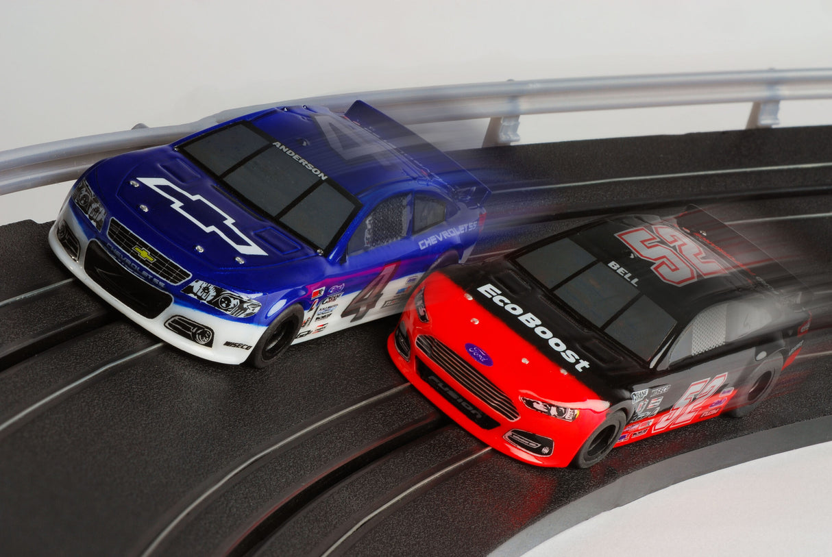 Two slot car race cars, one blue and one red, on a track for AFX/Racemasters 22041