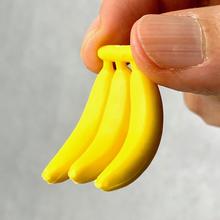 Yellow banana-shaped eraser held by fingers for BC Mini 38371