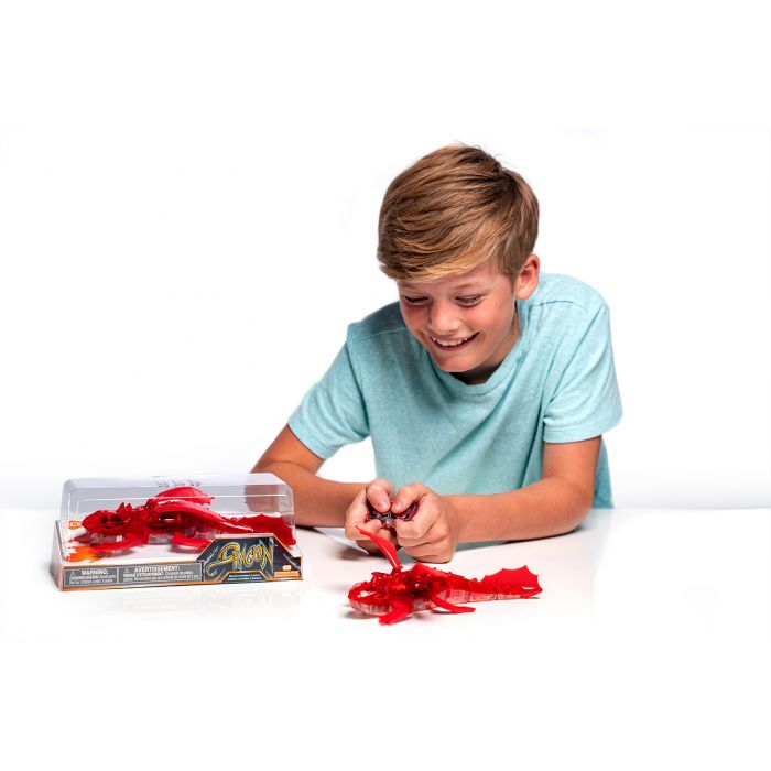 Boy crafting red dragon craft pieces on a white surface for HexBug 409-6847