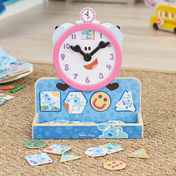 Blue's Clues wooden clock and matching magnetic puzzle pieces on a rug for Melissa and Doug 33014