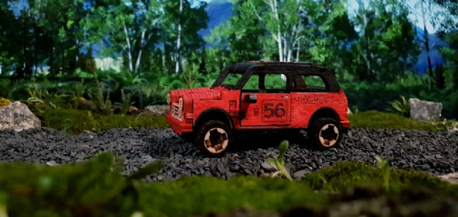 Red wooden rally car on a mossy, natural ground setting for Wooden City 502382