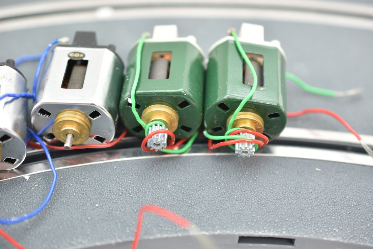 Row of small electric motors with wires attached to a surface for Mabuchi 8-Motors