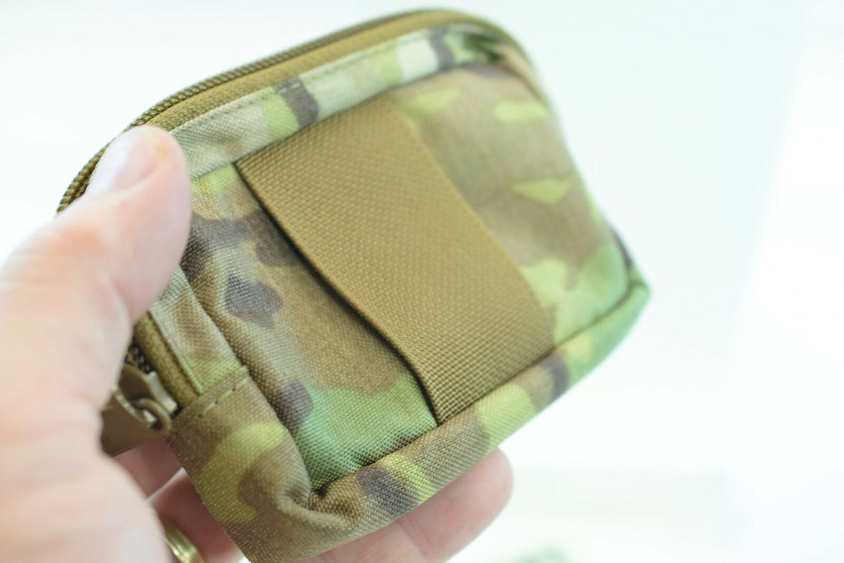 Camouflage wallet held in hand, showing zipper and flap closure for While The Cigars Lit WTCL001