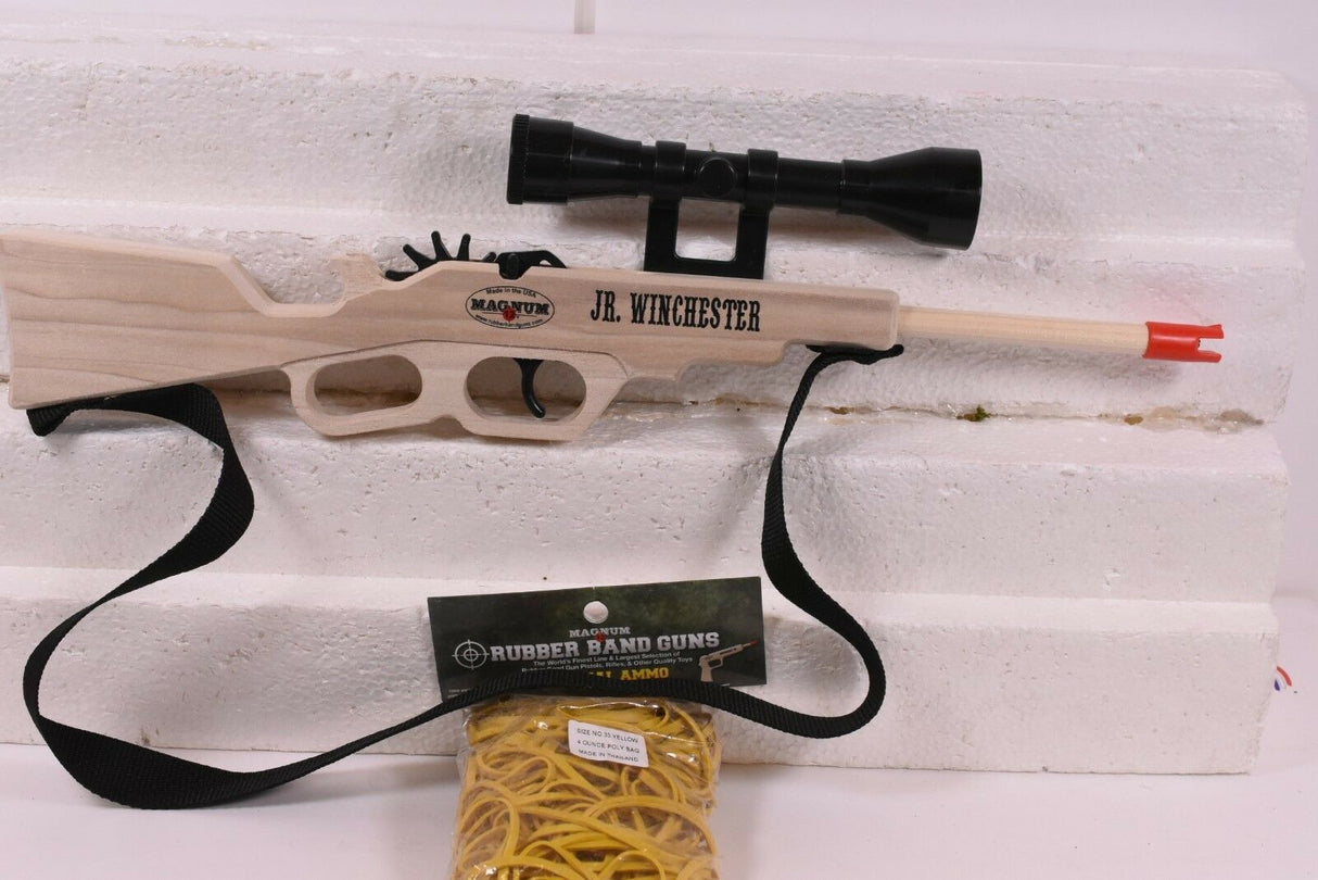 Toy rifle, scope, and yellow rubber band ammo set on white surface for Magnum Rubber Band Guns GL2JRWNCHSTRSS