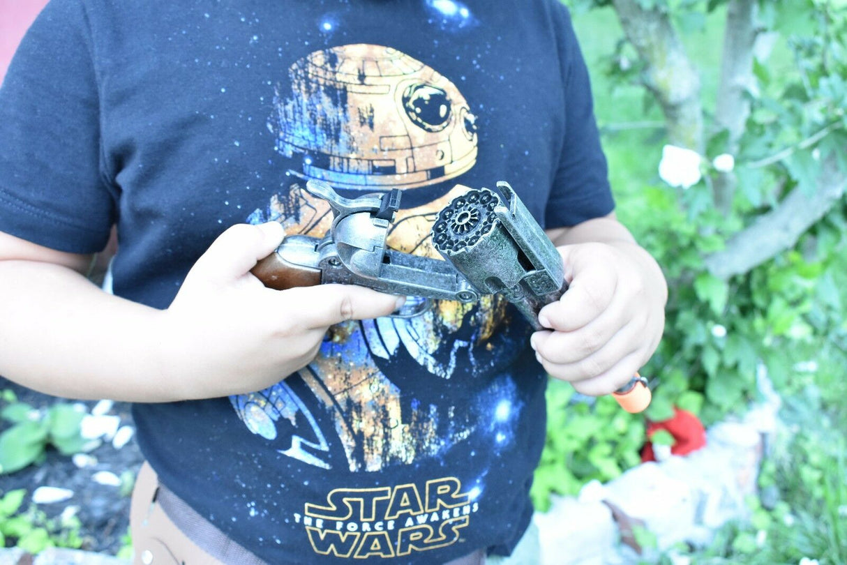 Child holding a toy revolver and holster against a Star Wars shirt for Parris Toys 4603C