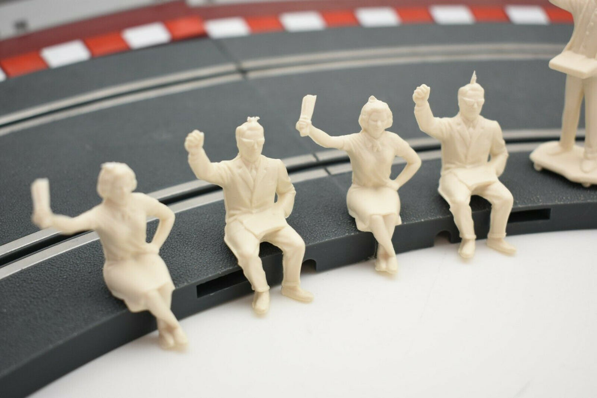 Group of unpainted 1/32 scale motor racing spectator figures on a track section for HORNBY 303058821440