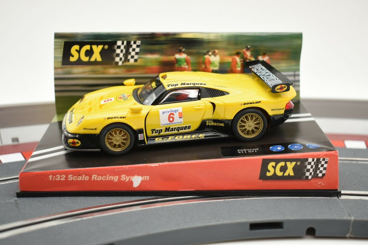 Yellow Porsche 911 GT1 race car on a track base for SCX Analog 60150, track detail view