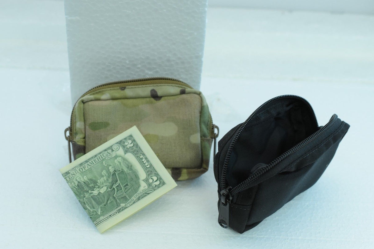 Wallet set with camouflage pouch and black zippered case, next to a dollar bill for While The Cigars Lit WTCL001