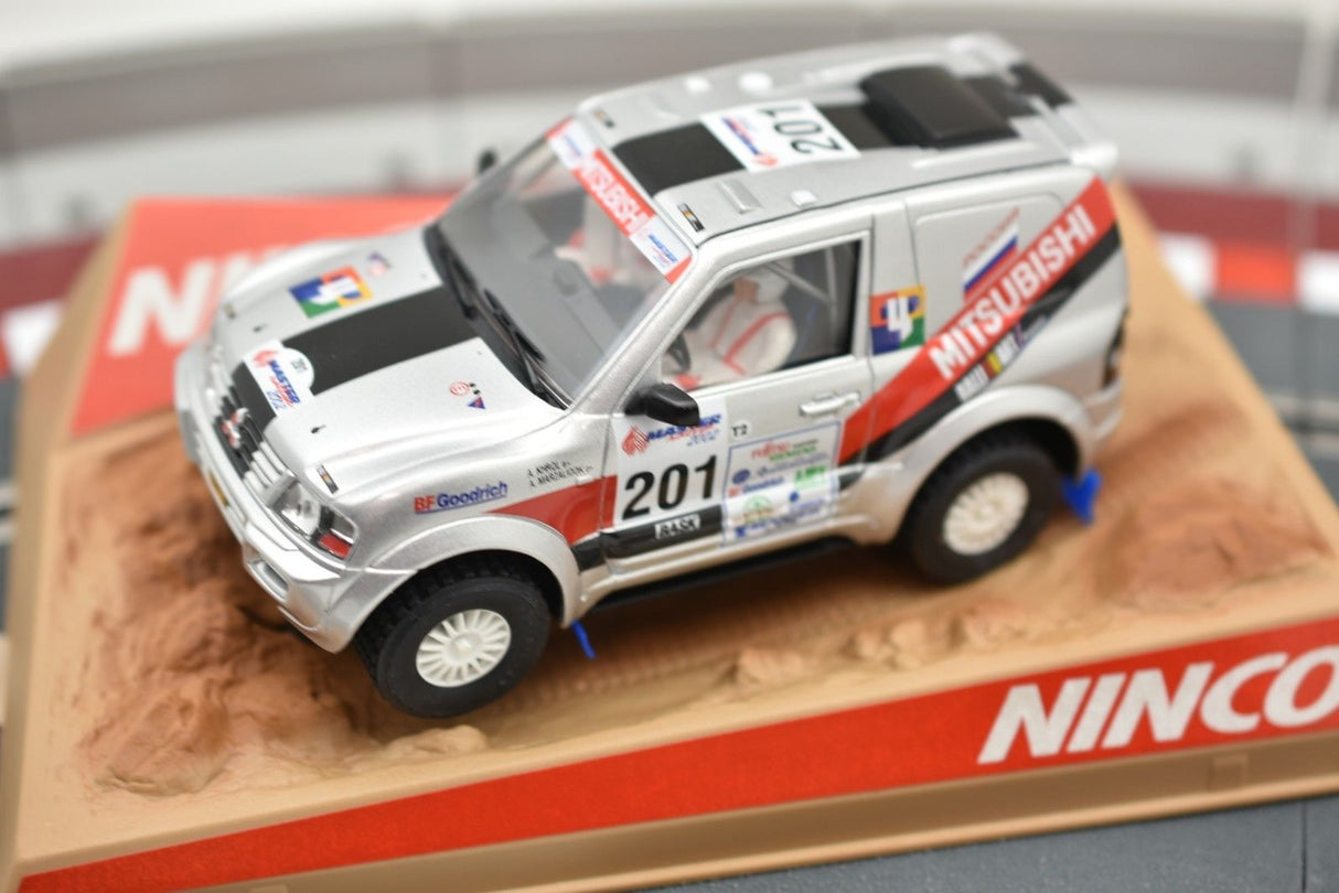 Silver Mitsubishi Pajero toy car on a dirt track base for Ninco 50314