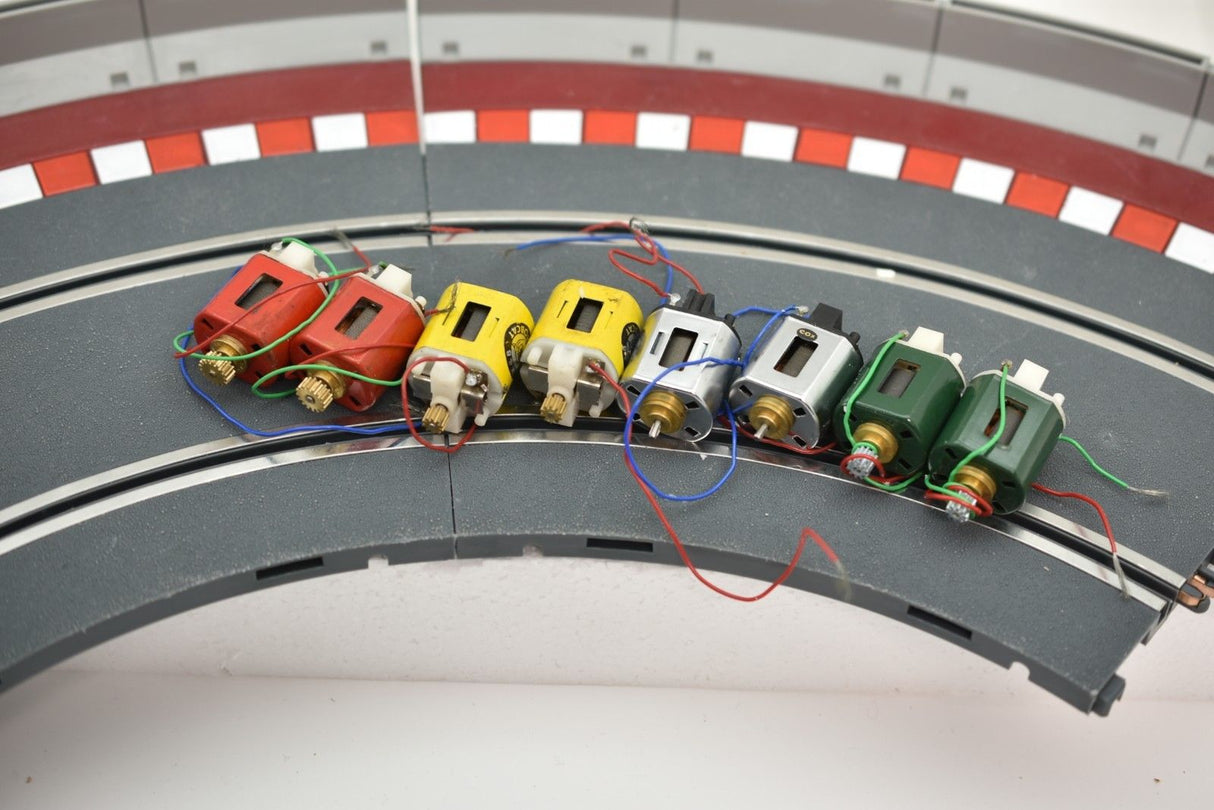 Row of small electric motors attached to a curved metal base for Mabuchi 8-Motors