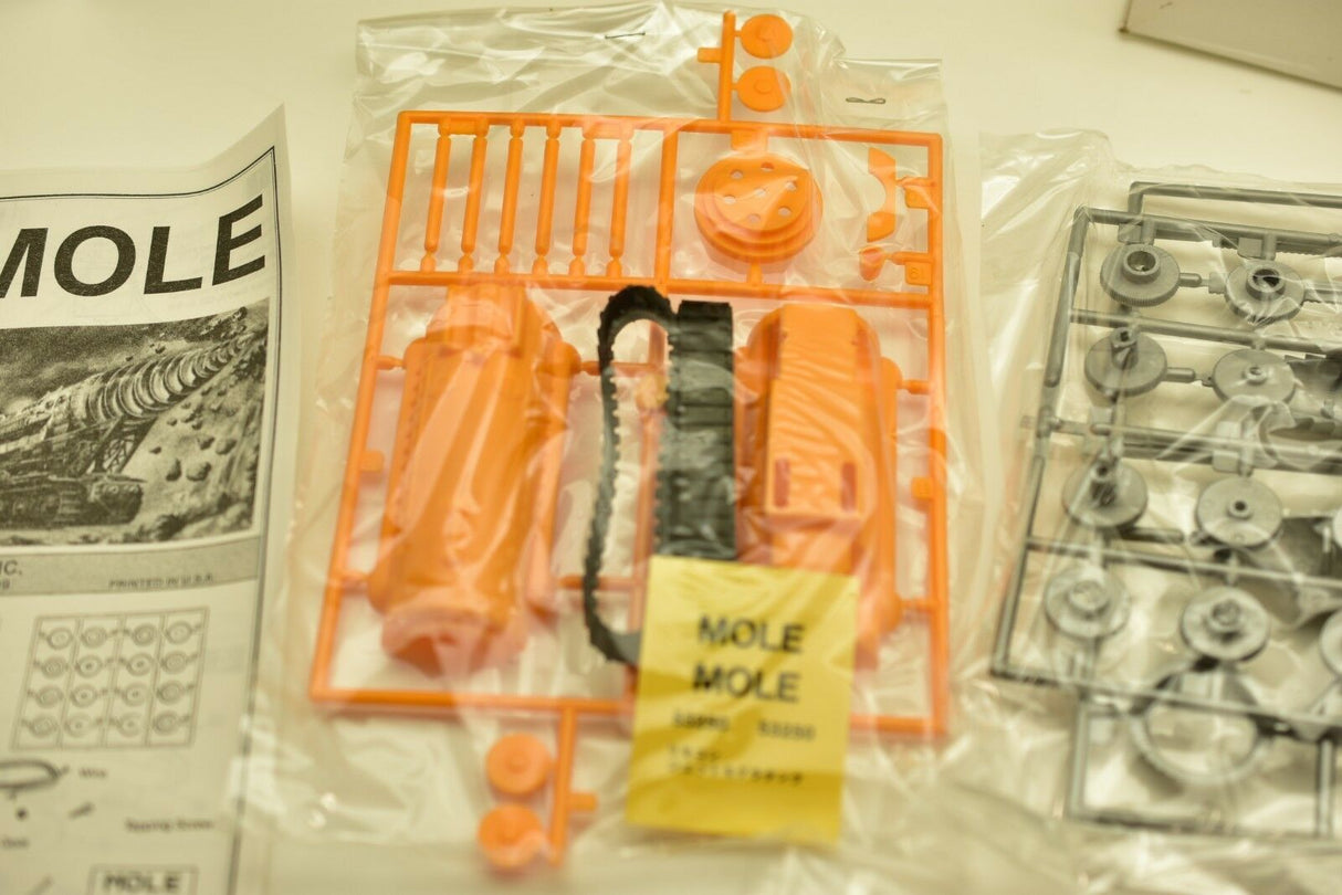 Assortment of orange and gray plastic parts for a mole kit for IMEX imx1214