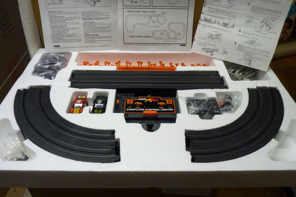 Race set components including track pieces, control center, and instruction manuals for Aurora Tomy AFX Vintage 8607M