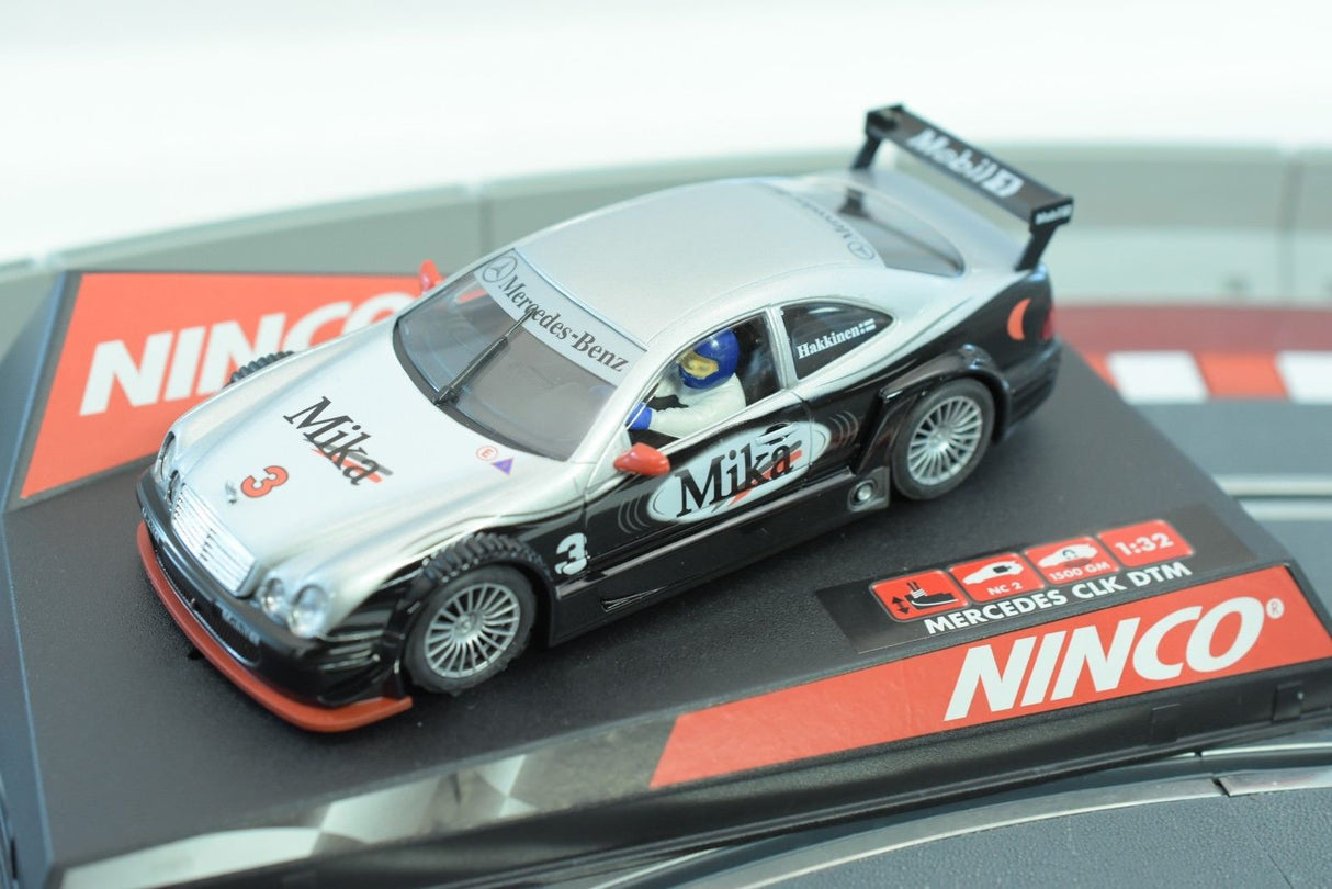 Silver Mercedes CLK DTM slot car with "Milka" branding on a black base for REH Ninco 50265