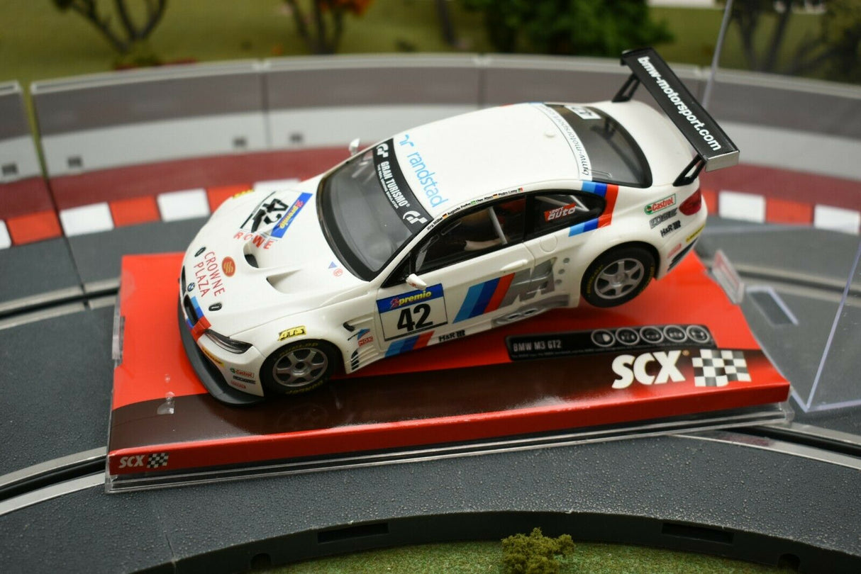White scale model BMW M3 GT2 race car on a display base for SCX A10156X3U0