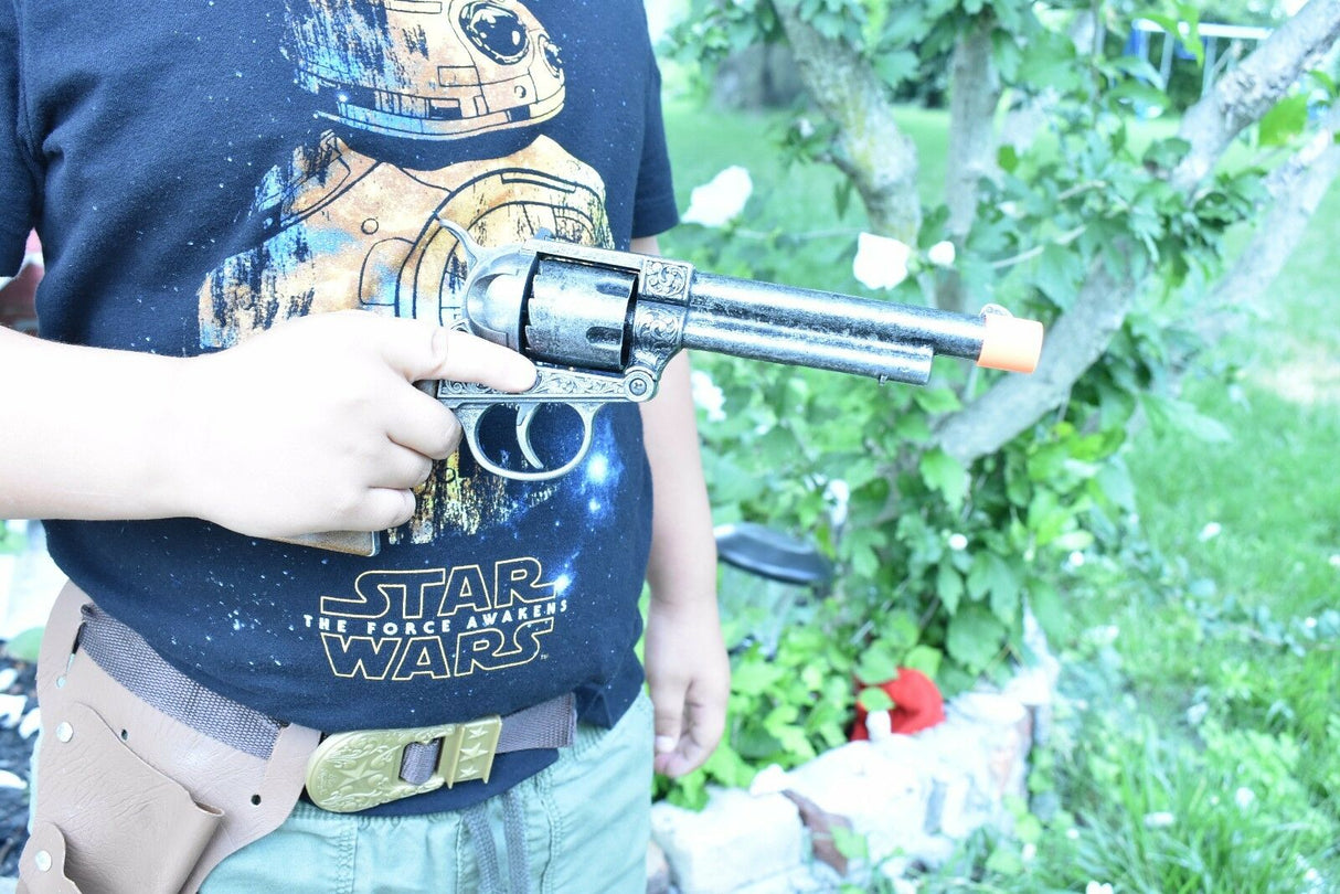 Boy holding a toy revolver and holster set outdoors for Parris Toys 4603C