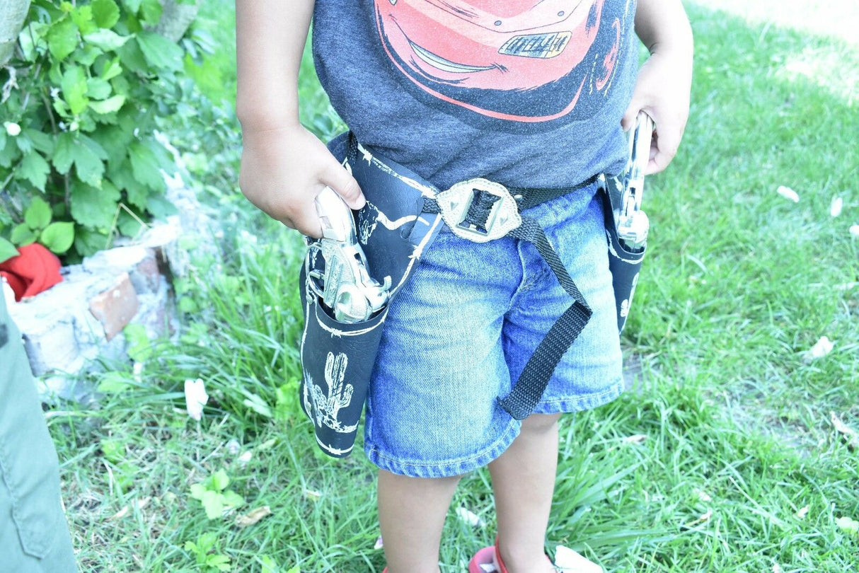 Child wearing a holster with toy pistols on a grassy lawn for Parris Toys 5506