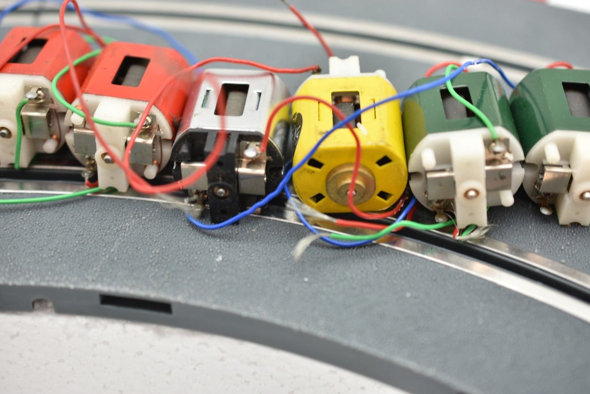 Row of small electric motors with visible wiring connections for Mabuchi 8-Motors