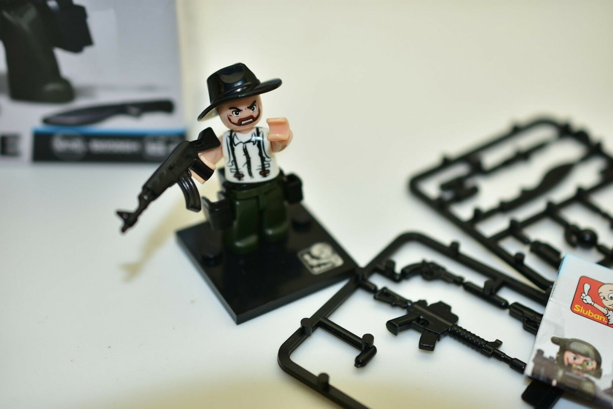 Miniature police officer figure with gun, set on a black base for Sluban M38-B0586