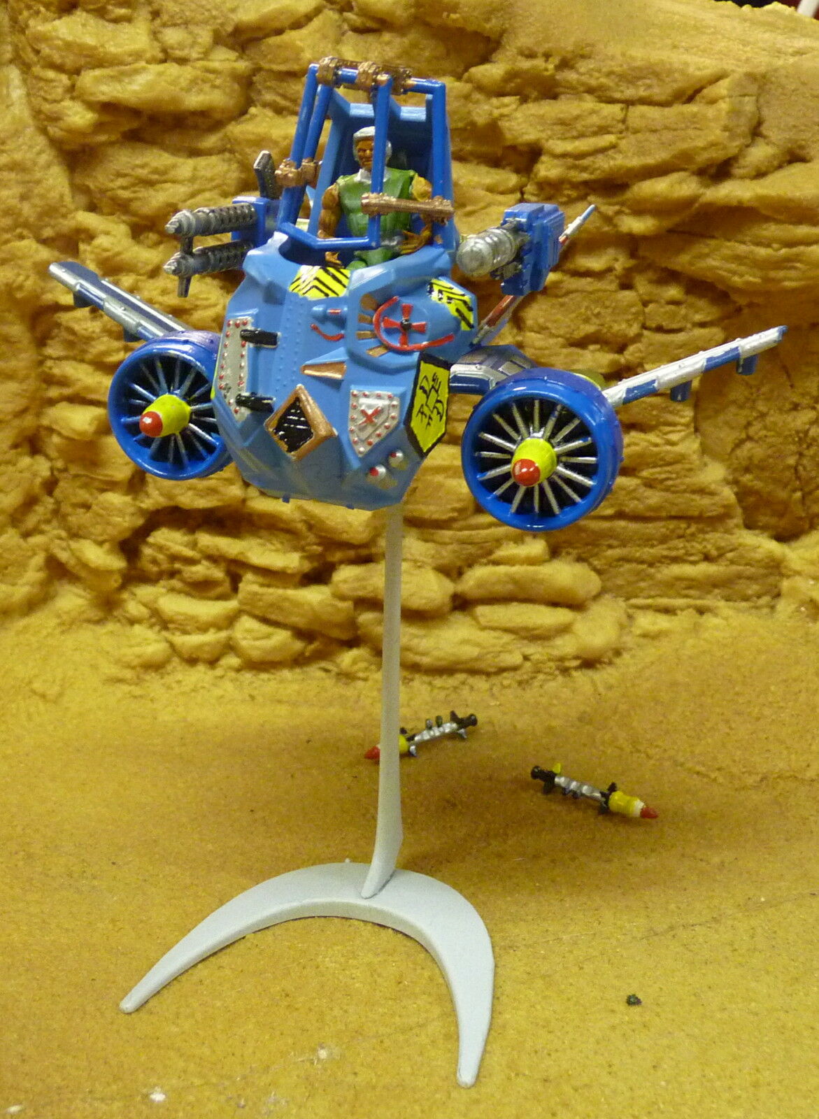 Blue, mechanical vehicle toy on a stand against a yellow, textured background for Robogear 6005