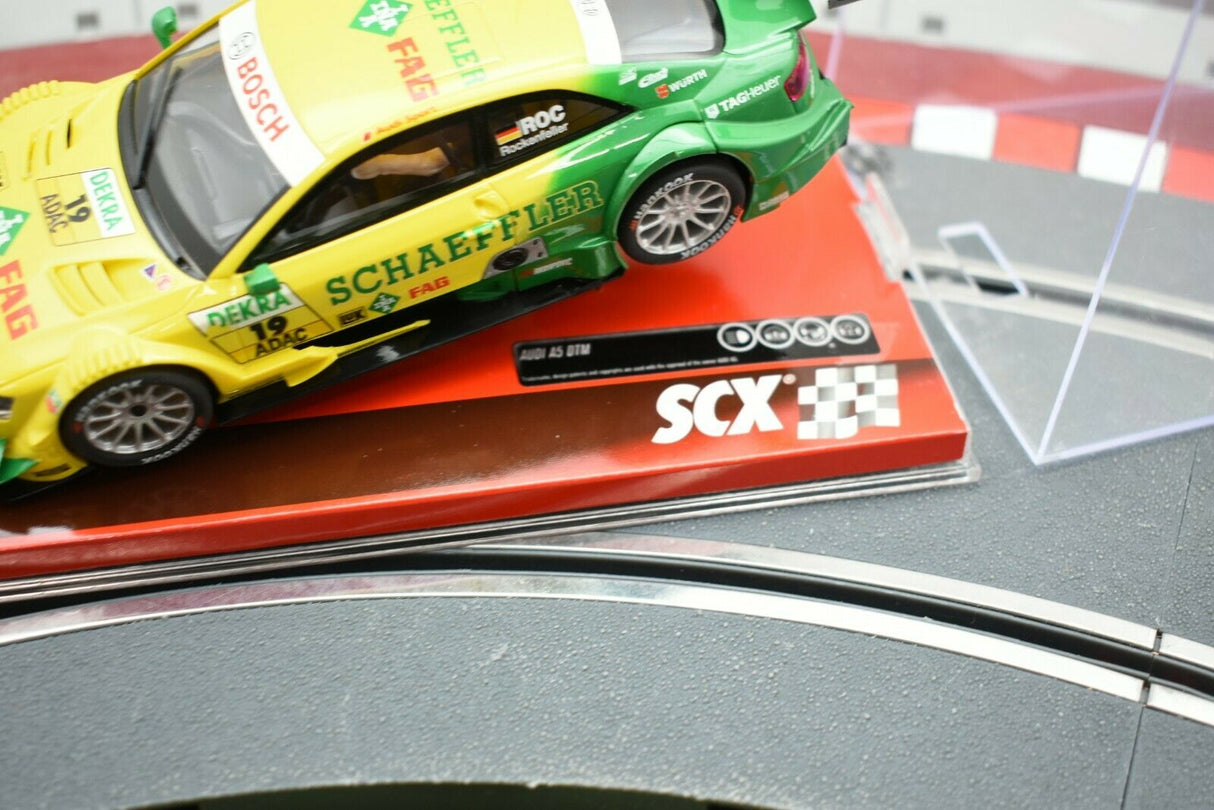 Yellow and green race cars on a display base for SCX A10161X3U0