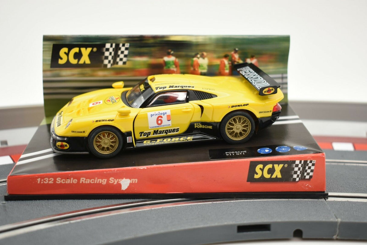 Yellow Porsche 911 GT1 race car on a track base for SCX Analog 60150, track view