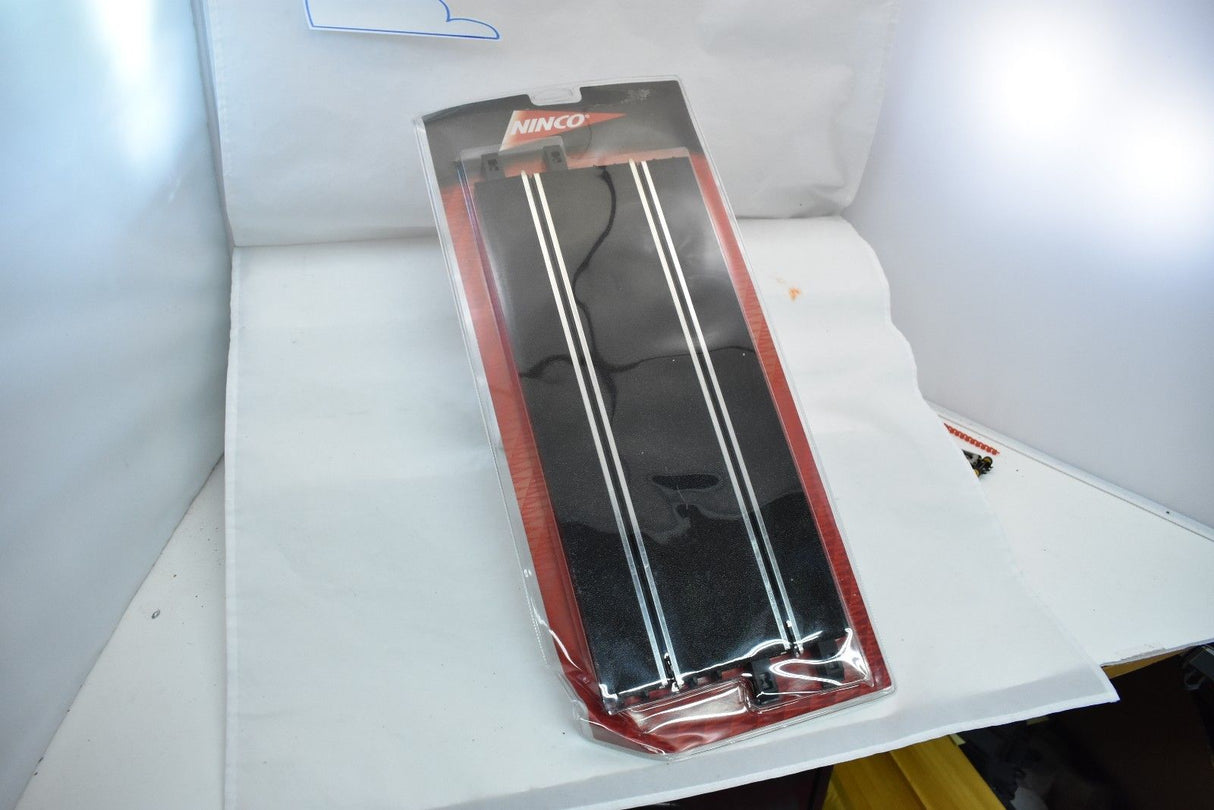 Two straight, black metal rods packaged in a red plastic case for Ninco 10102