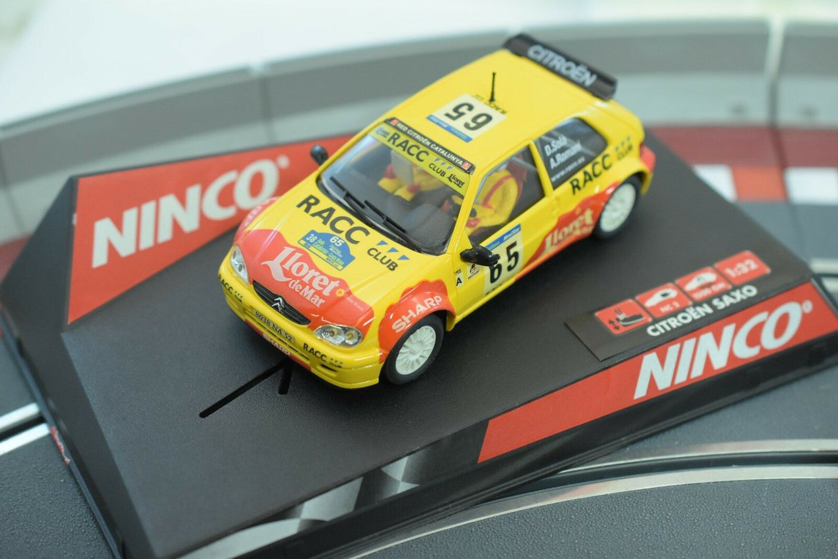 Yellow slot car replica of a Citroen Saxo race car on a track base for Ninco 50266