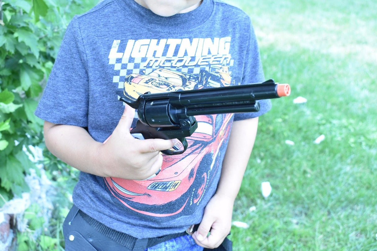 Boy holding a toy black revolver outdoors for Parris Toys 4708B