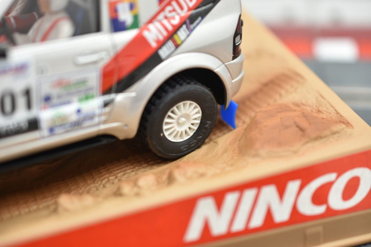 Silver Mitsubishi Pajero model car on a textured surface with Ninco branding for 50314