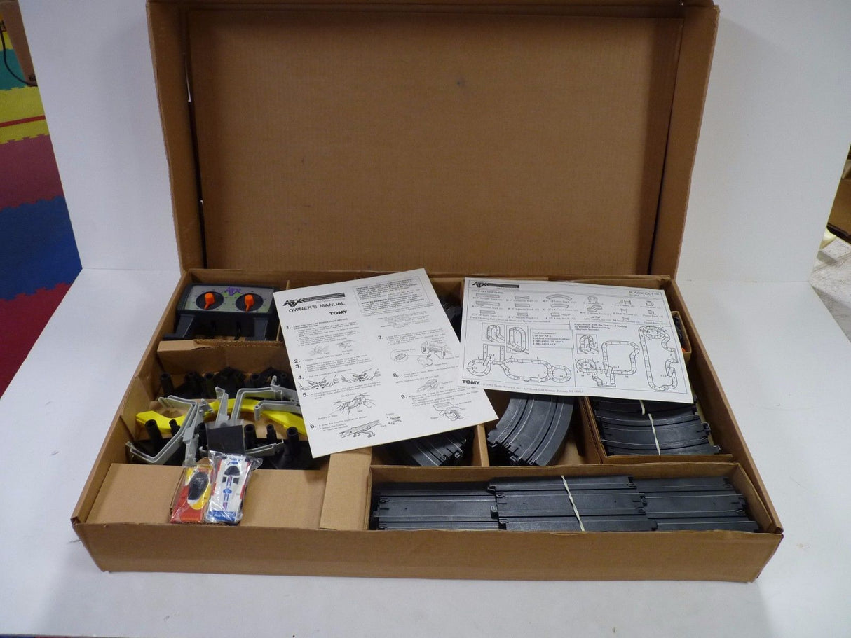 Model train set components in an open cardboard box for Aurora / AFX / Tomy 9115M