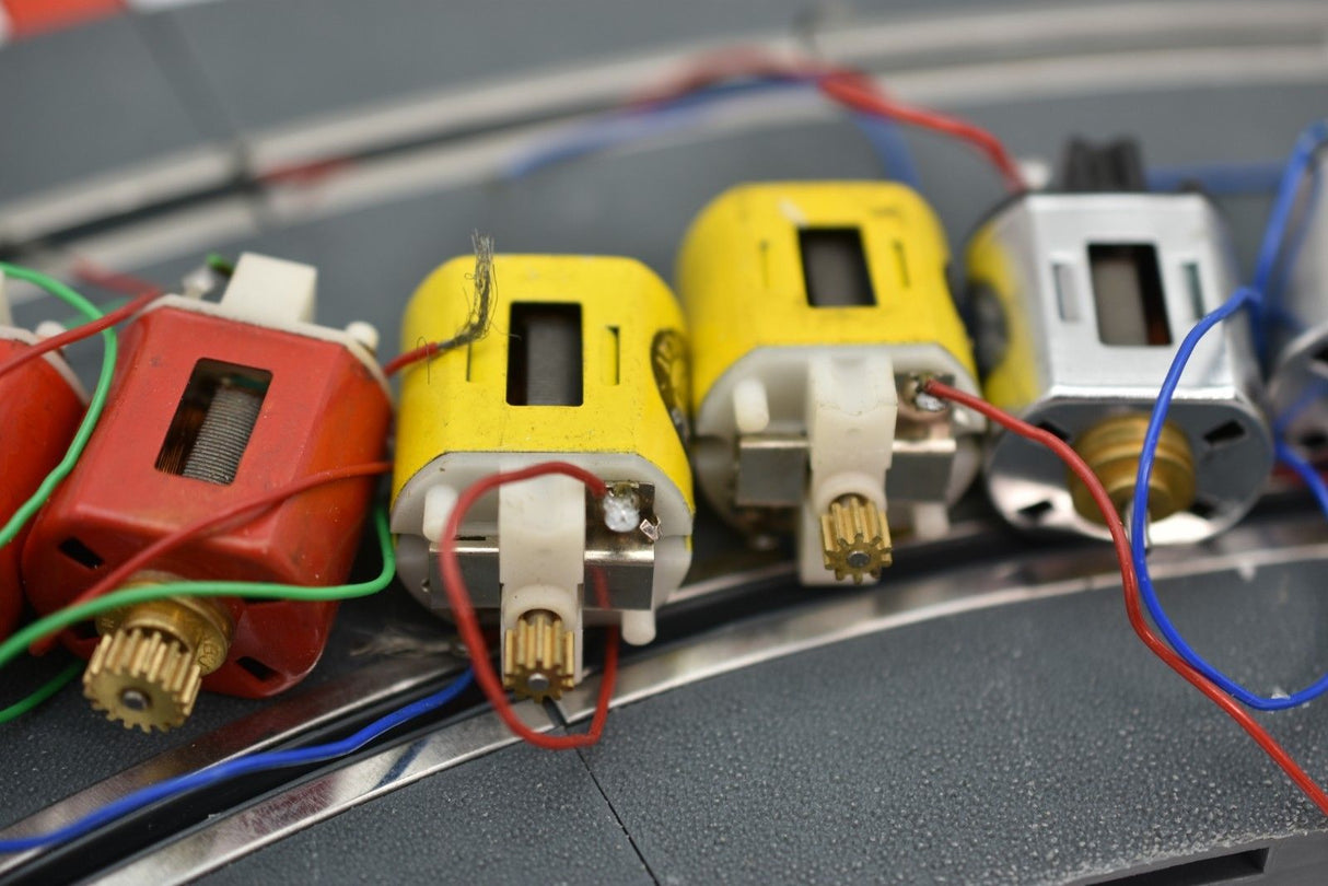 Assortment of small electric motors with wires connected, showing various colors and sizes for Mabuchi 8-Motors