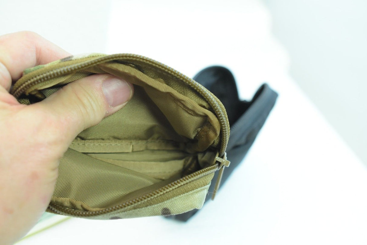 Hand holding open khaki wallet showing interior compartments for While The Cigars Lit WTCL001