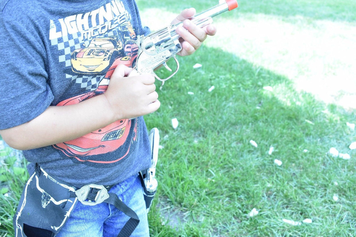 Child holding a toy replica pistol outdoors with a holster belt for Parris Toys 5506