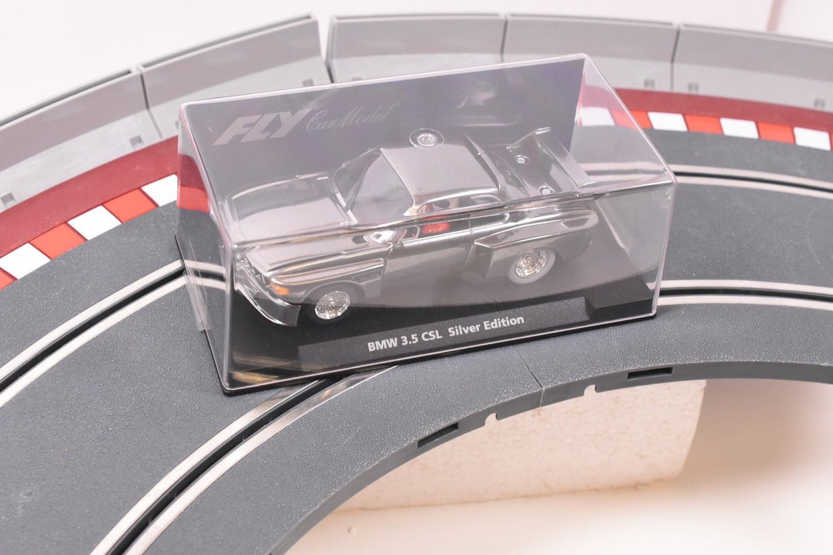 Clear case displaying a silver BMW 3.5 CSL model car on a track section for Fly Car 88124
