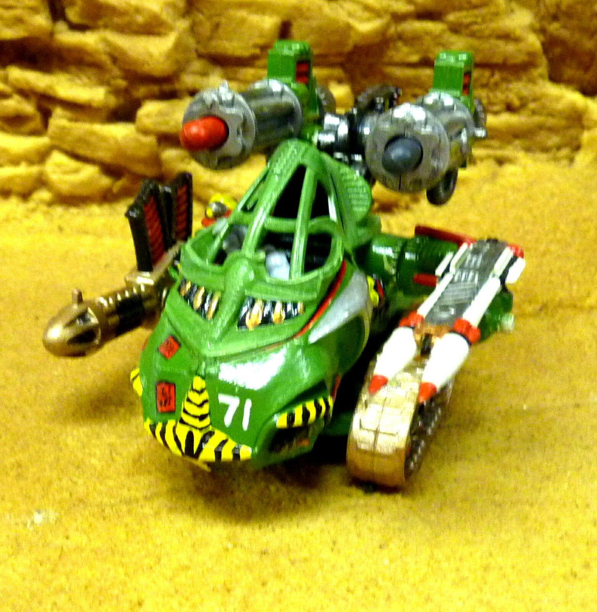 Green robot toy with yellow accents, posed on yellow ground for Robogear 6008