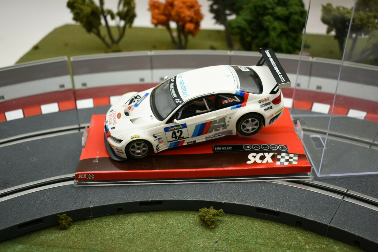 White race car model on a track section with green grass background for SCX A10156X3U0