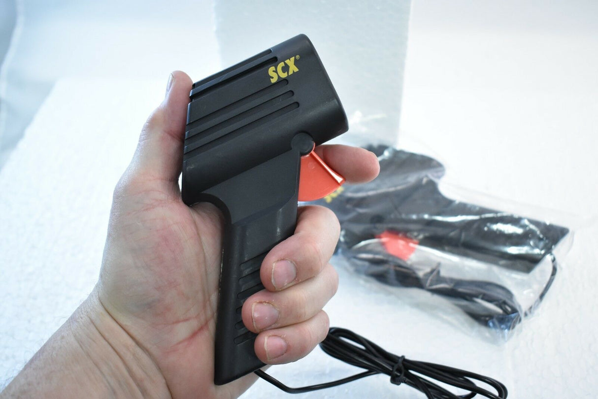 Hand holding a black throttle control with "SCX" visible for A08879X200